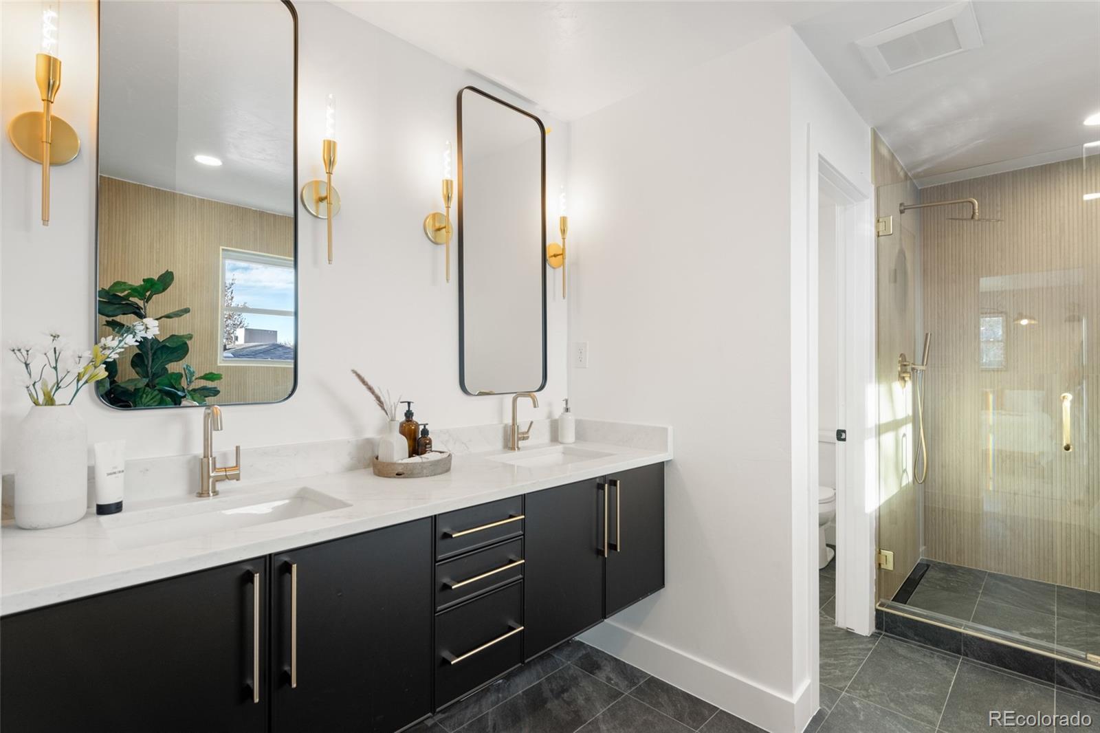 3380 Ward Road Wheat Ridge, CO 80033 - Photo 20 of 37 a bathroom with a double vanity sink mirror and shower