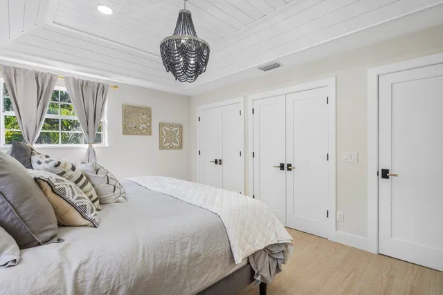 a bedroom with a large bed and a chandelier