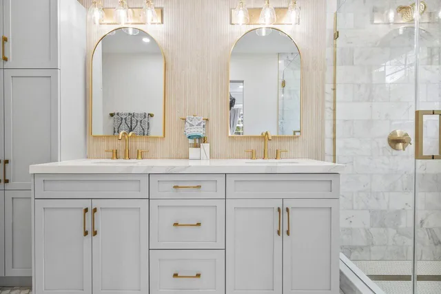 a bathroom with a double vanity sink mirror and shower