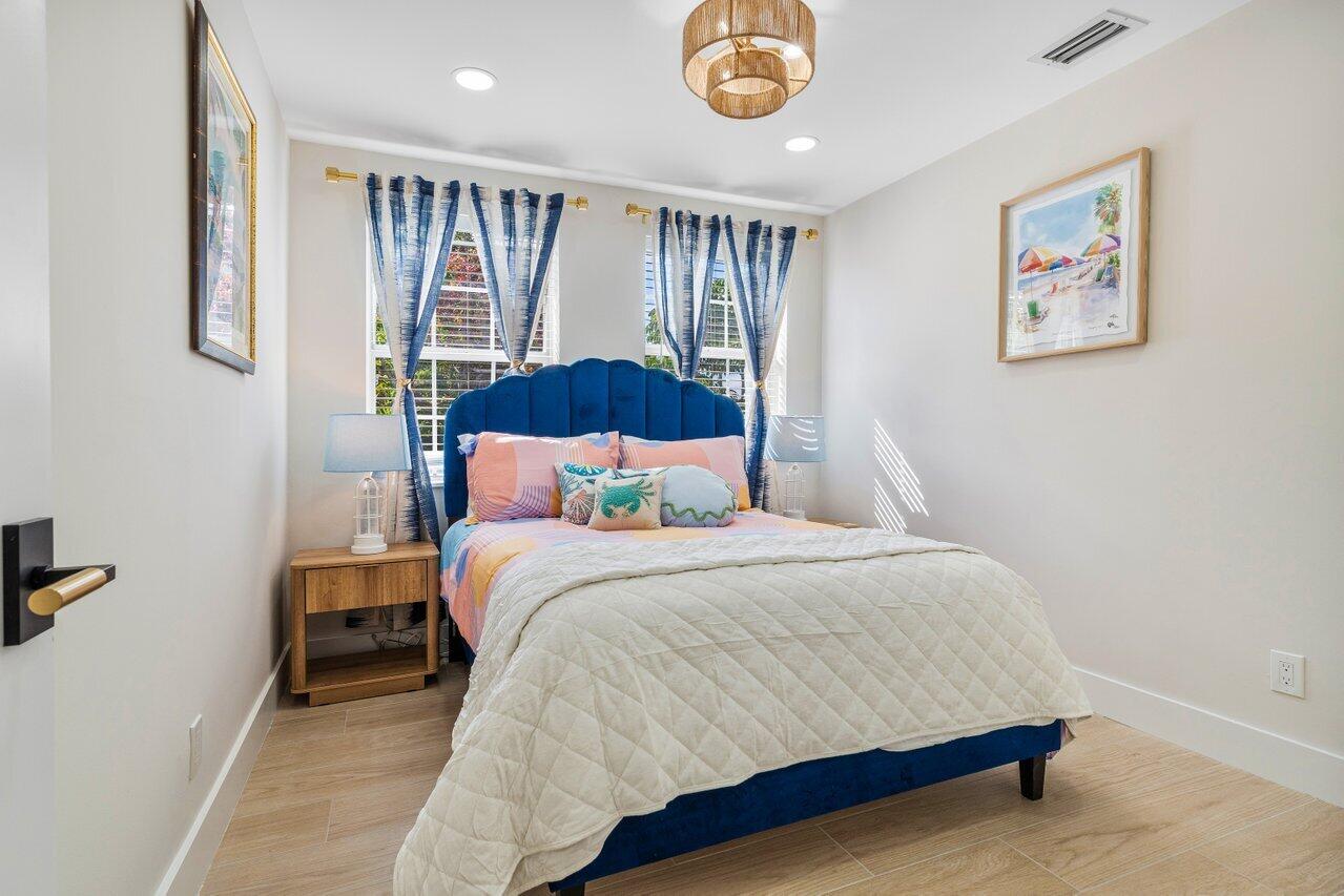 1920 Spanish Trail Delray Beach, FL 33483 - Photo 20 of 23 a bedroom with a bed and a painting on the wall