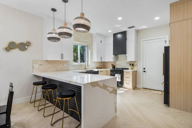 a kitchen with kitchen island stainless steel appliances a sink and a refrigerator