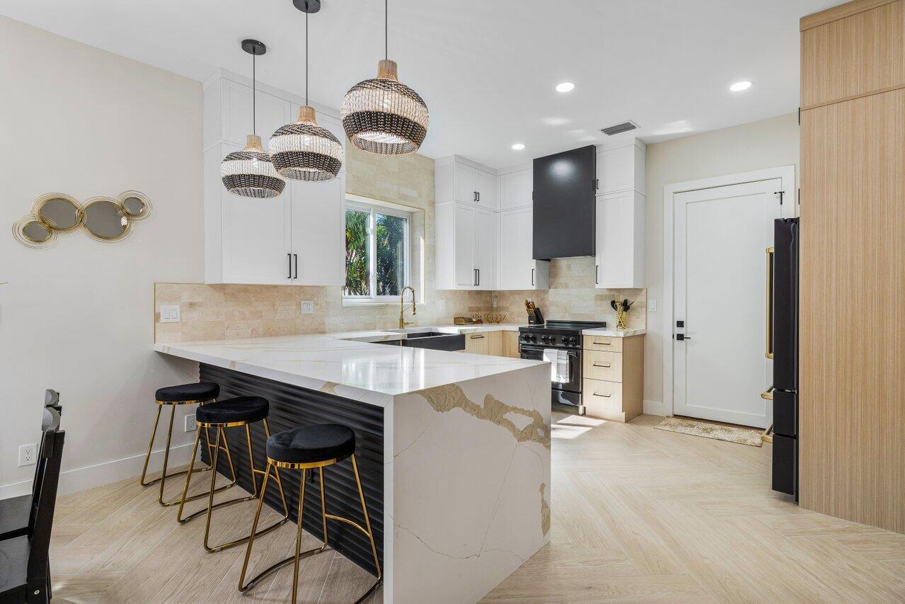 1920 Spanish Trail Delray Beach, FL 33483 - Photo 10 of 23 a kitchen with kitchen island stainless steel appliances a sink and a refrigerator