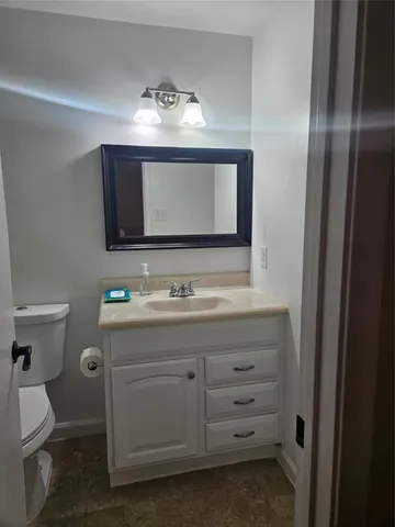 a bathroom with a toilet sink and mirror