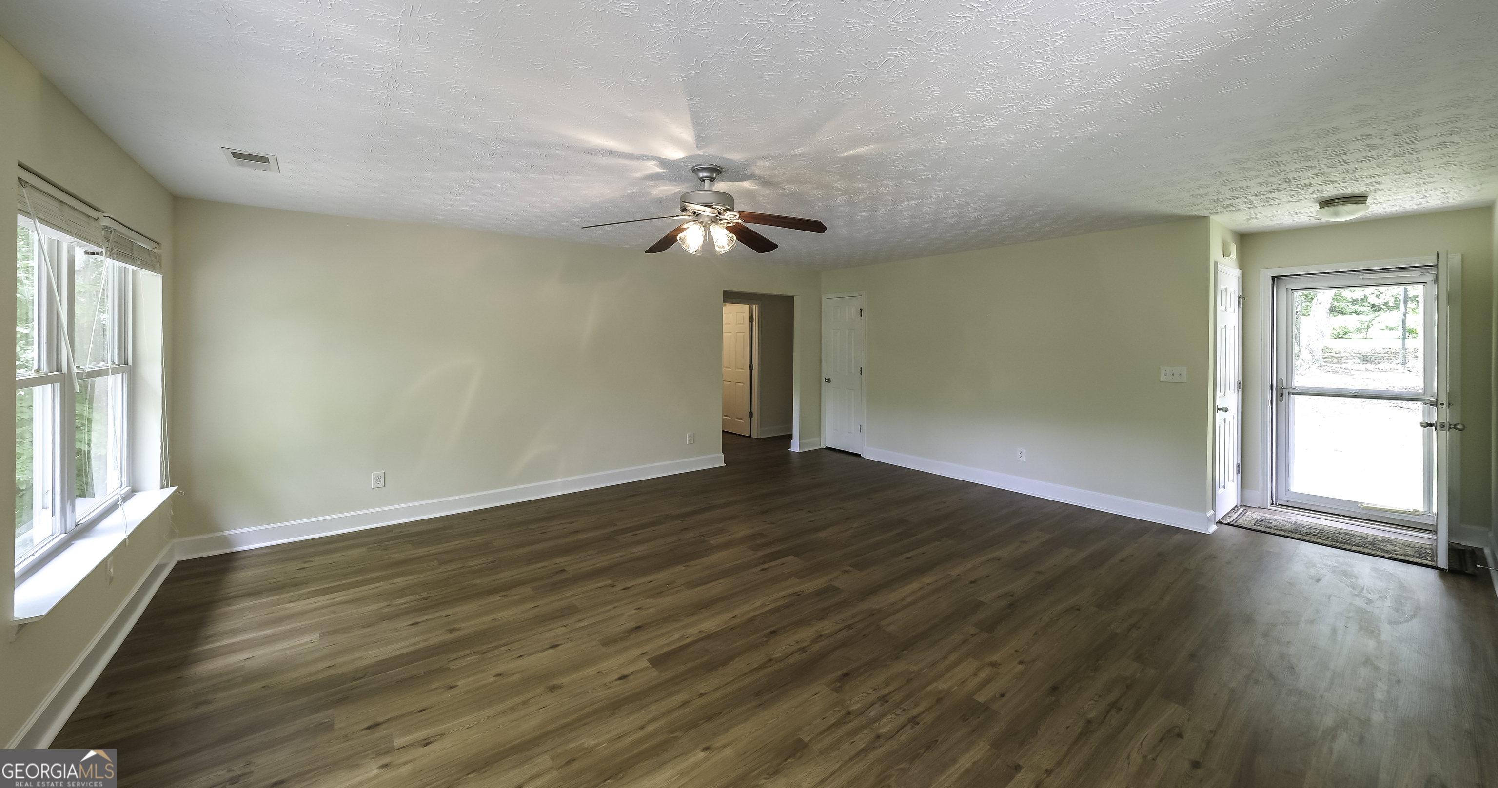 191 Tumlin Creek Road Roopville, GA 30170 - Photo 14 of 49 a view of empty room with wooden floor and fan