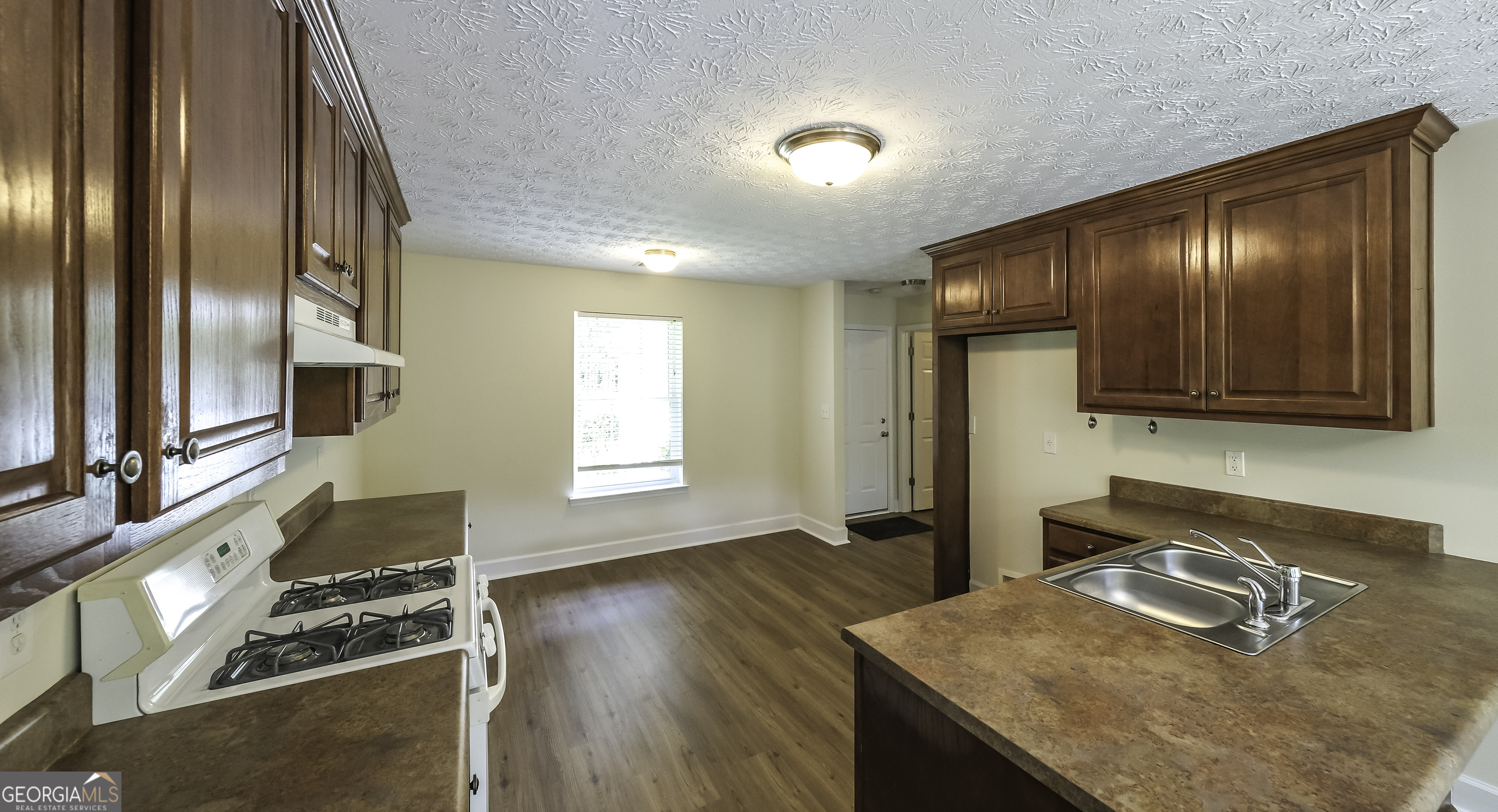 191 Tumlin Creek Road Roopville, GA 30170 - Photo 6 of 49 a kitchen with granite countertop wooden cabinets and a stove