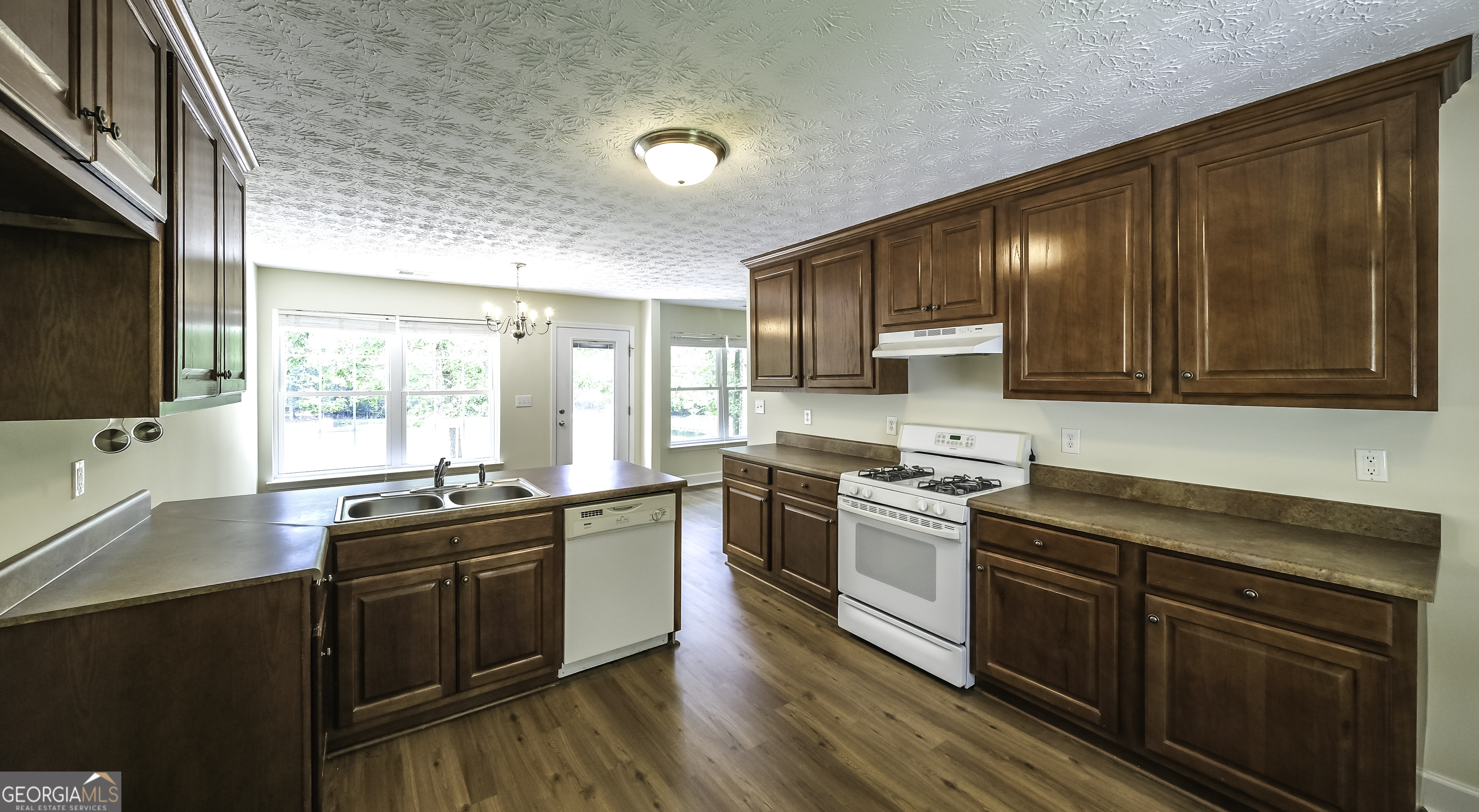 191 Tumlin Creek Road Roopville, GA 30170 - Photo 7 of 49 a kitchen with stainless steel appliances wooden cabinets and a stove top oven