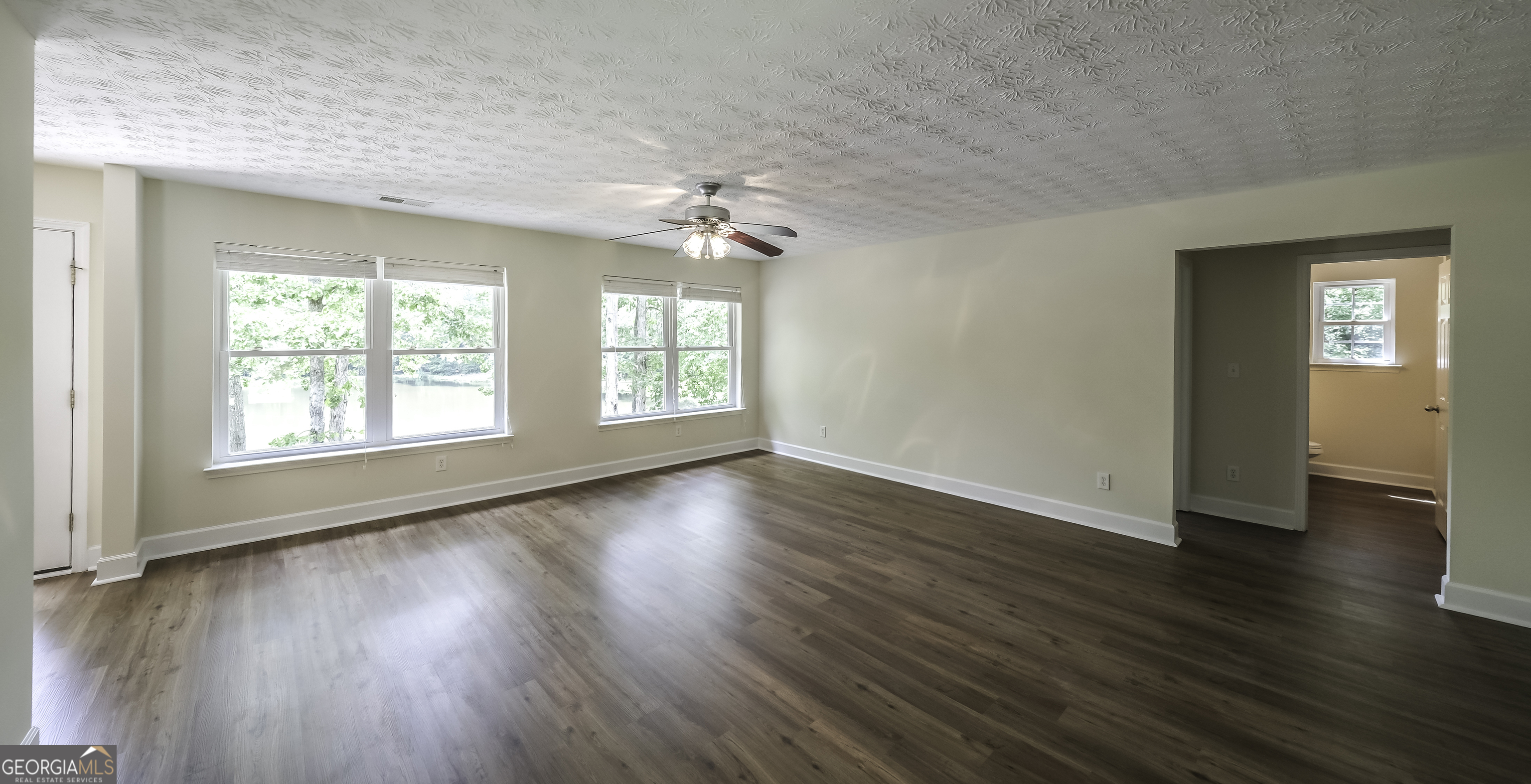 191 Tumlin Creek Road Roopville, GA 30170 - Photo 10 of 49 an empty room with wooden floor and windows