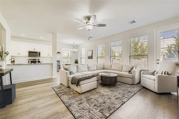 a living room with furniture and view of kitchen
