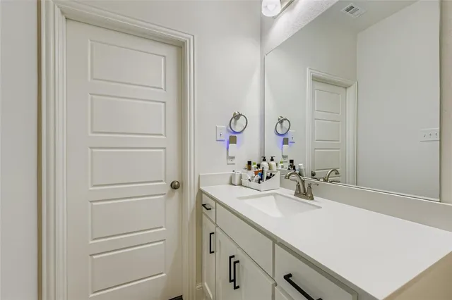 a en suite bathroom with a double vanity sink mirror and shower