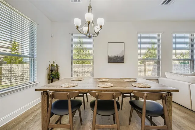 a view of a dining room with furniture wooden floor and chandelier