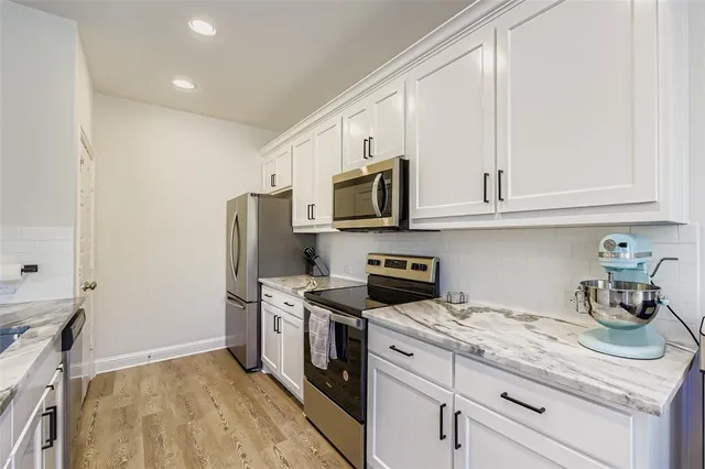 a kitchen with stainless steel appliances granite countertop a refrigerator and a stove top oven