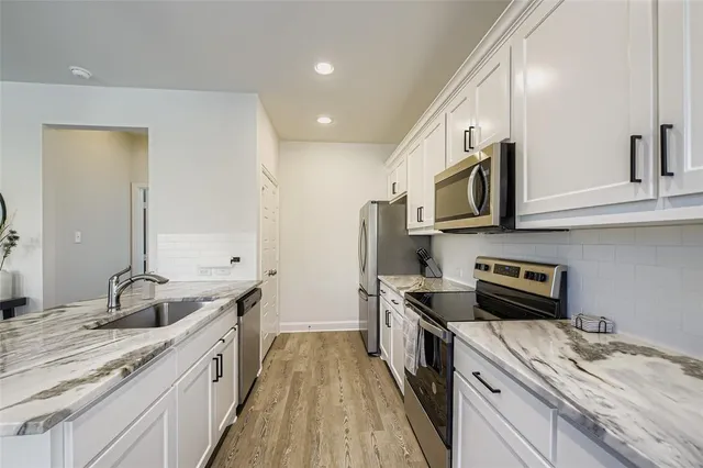 a large living room with stainless steel appliances granite countertop a couch and a flat screen tv