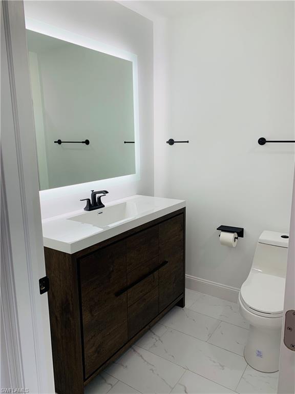 4180 5th Avenue Southwest Naples, FL 34119 - Photo 19 of 33 a bathroom with a sink toilet and a mirror
