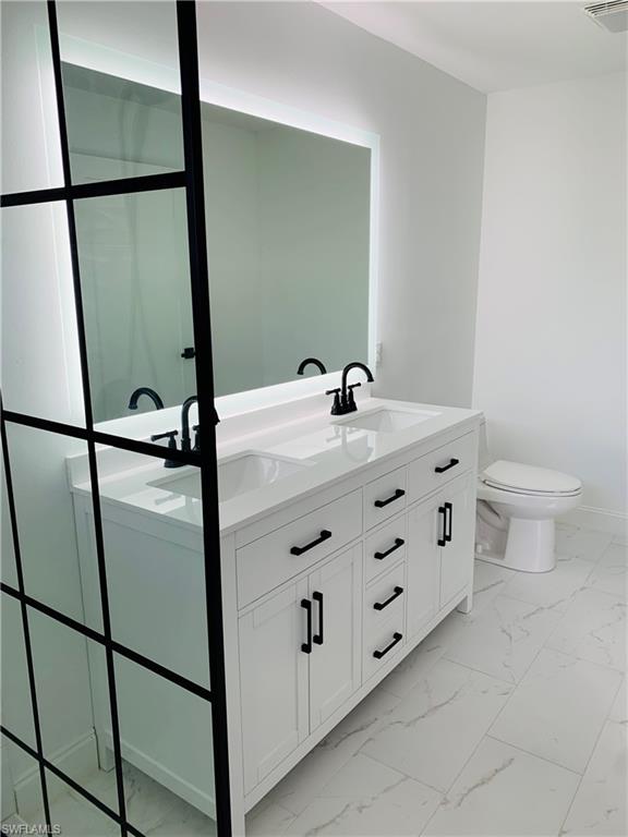 4180 5th Avenue Southwest Naples, FL 34119 - Photo 26 of 33 a bathroom with a sink toilet and mirror
