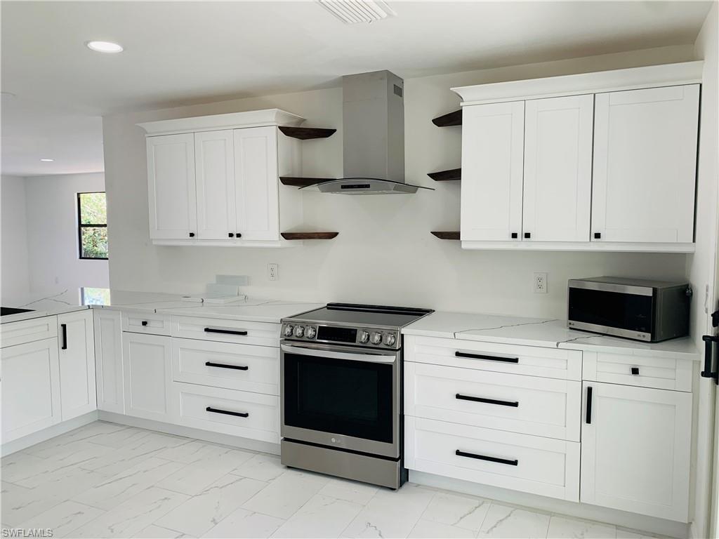 4180 5th Avenue Southwest Naples, FL 34119 - Photo 9 of 33 a kitchen with white cabinets and appliances