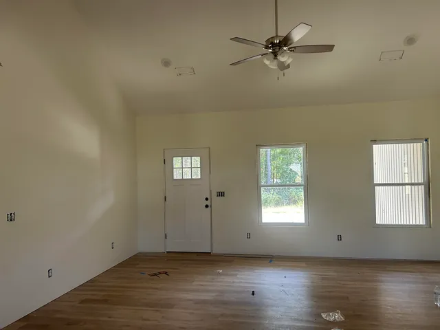 wooden floor in an empty room with a window