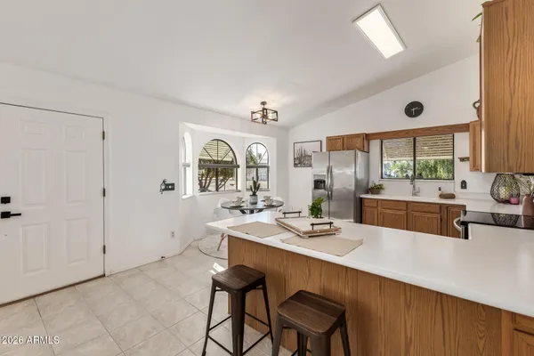 a dining hall with stainless steel appliances kitchen island granite countertop a dining table and chairs