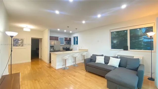 a living room with stainless steel appliances kitchen island granite countertop furniture and a kitchen view