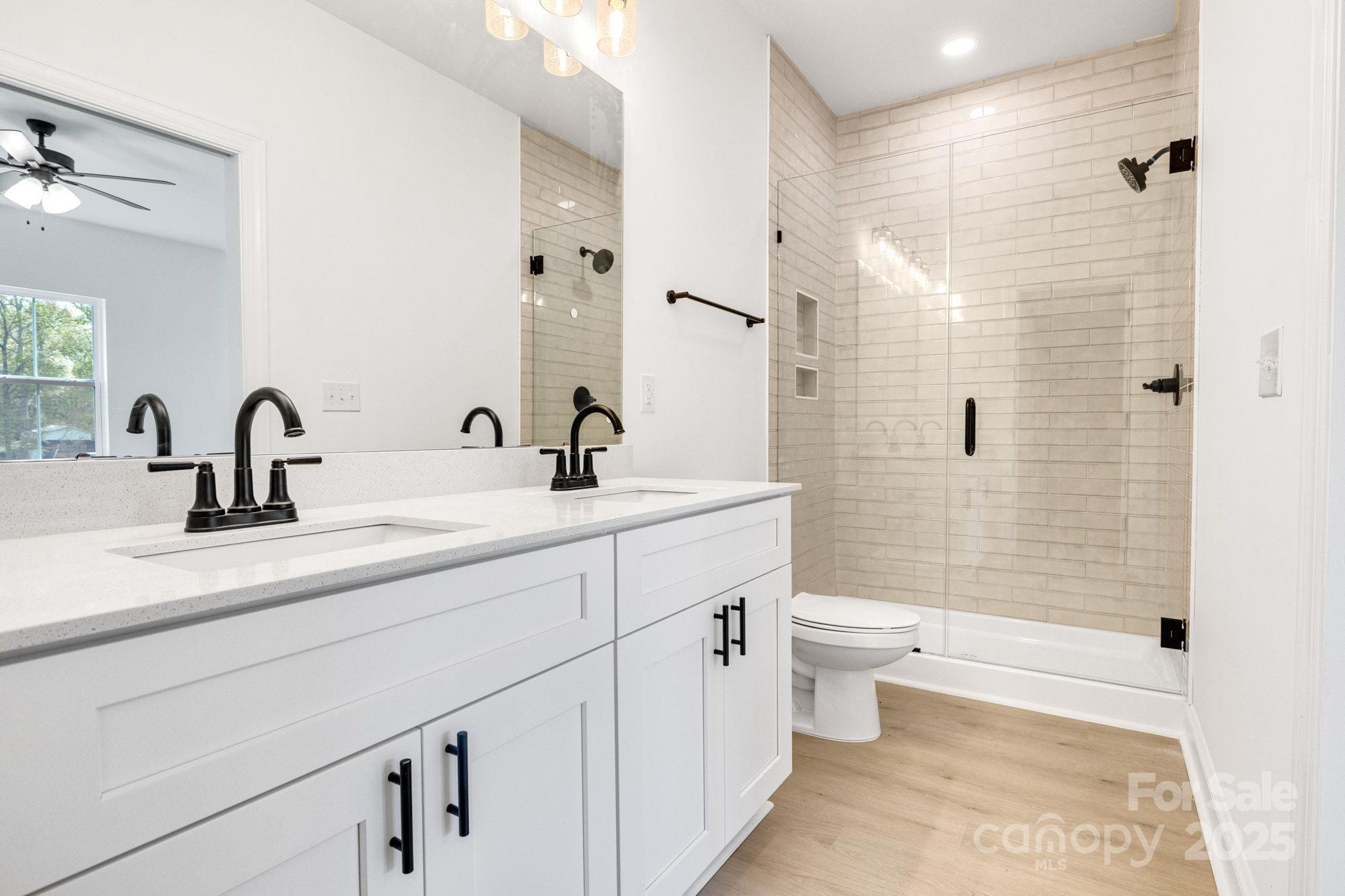 540 Church Street Locust, NC 28097 - Photo 11 of 25 a bathroom with a double vanity sink toilet and shower
