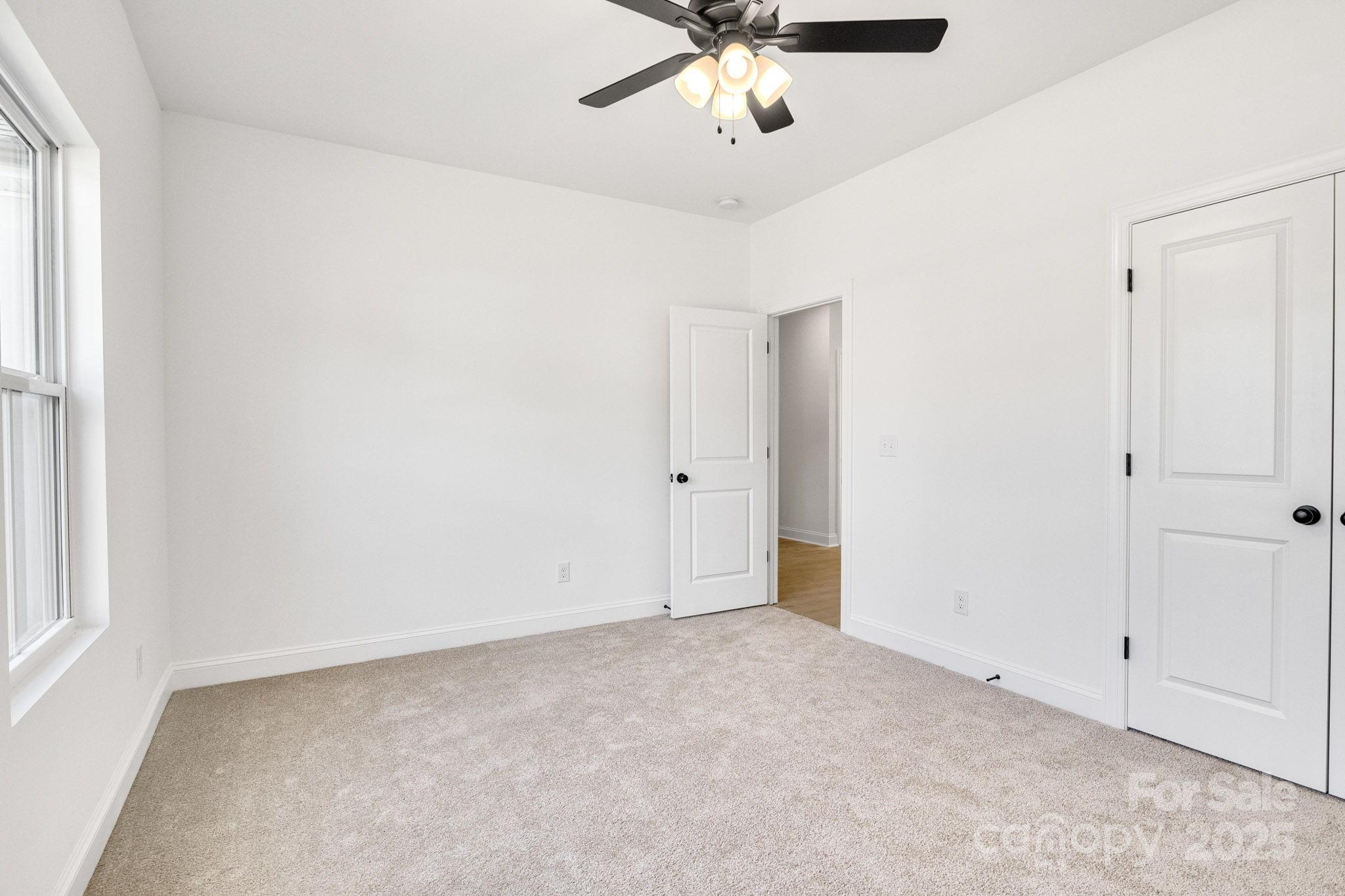 540 Church Street Locust, NC 28097 - Photo 14 of 25 an empty room with a window and a chandelier fan