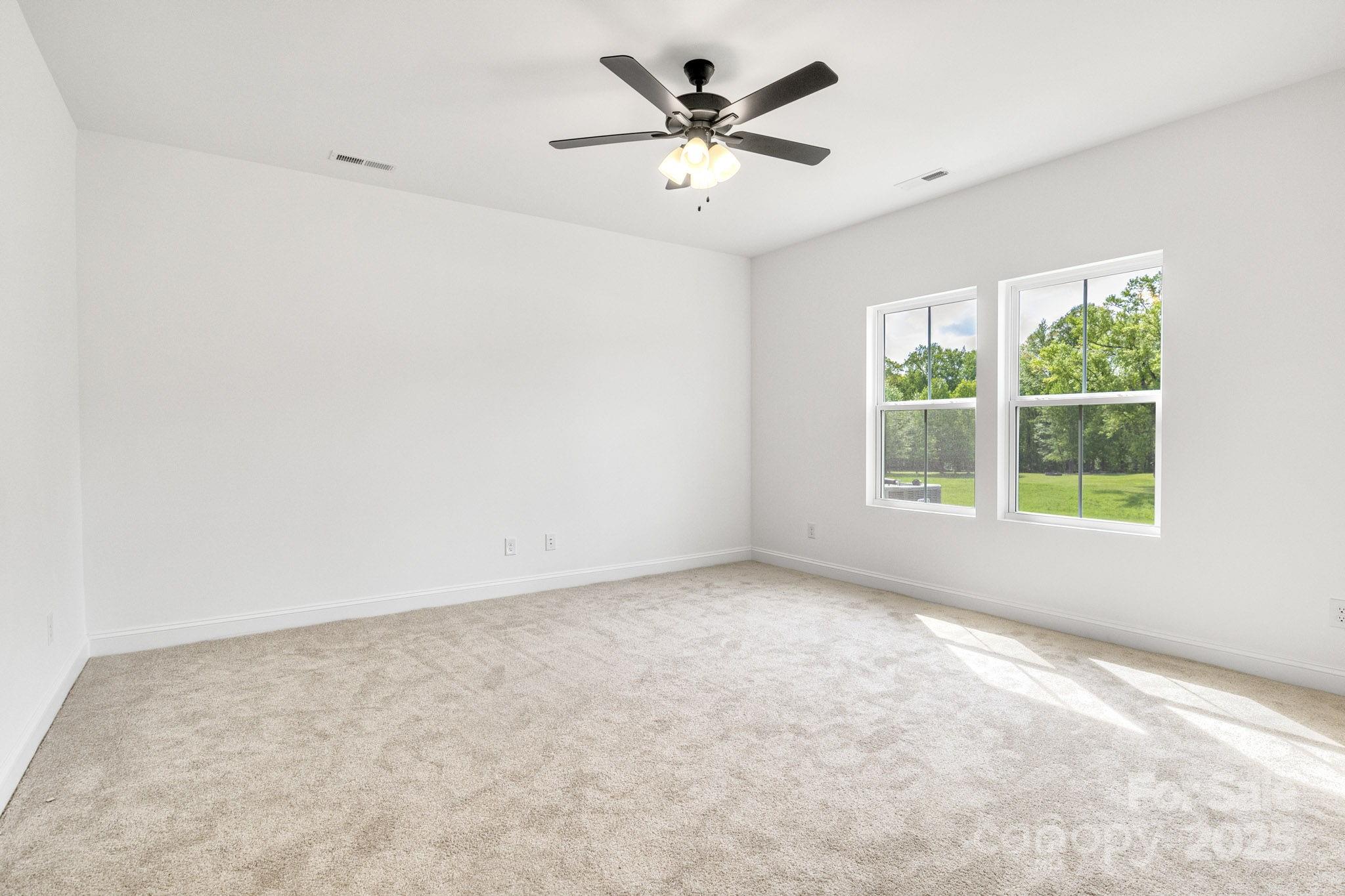 540 Church Street Locust, NC 28097 - Photo 17 of 25 an empty room with a window and a ceiling fan