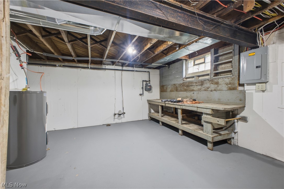 3232 Bears Den Road Youngstown, OH 44511 - Photo 25 of 38 Lower-level space featuring an exposed ceiling with wood joists and steel beams, painted concrete flooring, and a dedicated utility area