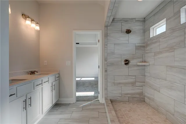 a bathroom with a granite countertop sink a toilet and shower