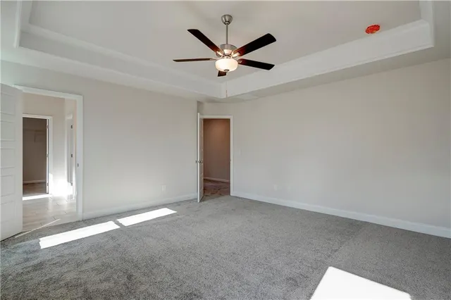 an empty room with closet and ceiling fan