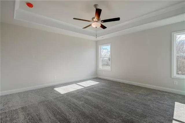 an empty room with windows and fan