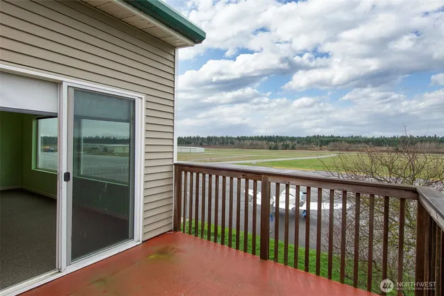 a view of a house next to a big yard and large trees