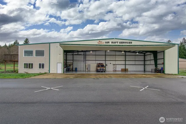 a view of a big house with a big yard and large trees