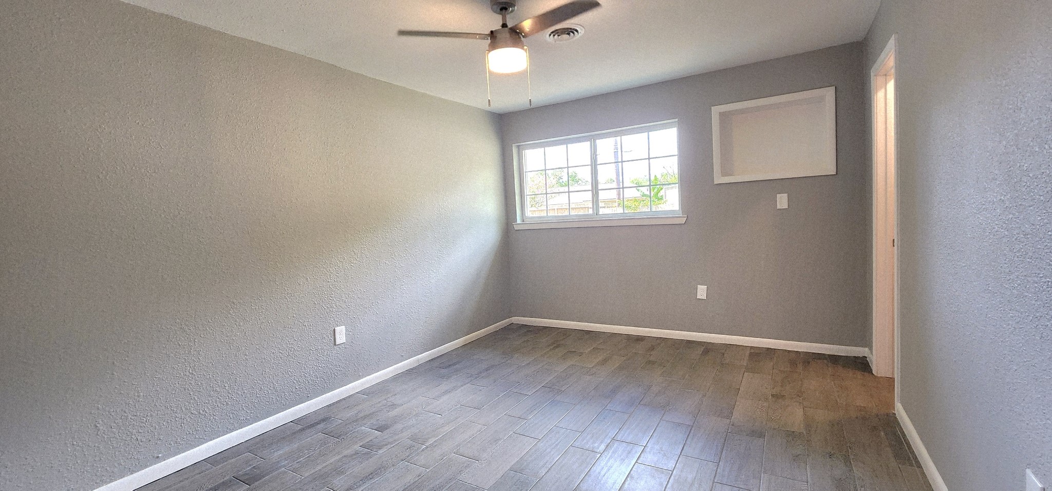 5914 Newquay Street Houston, TX 77085 - Photo 17 of 43 an empty room with wooden floor and windows