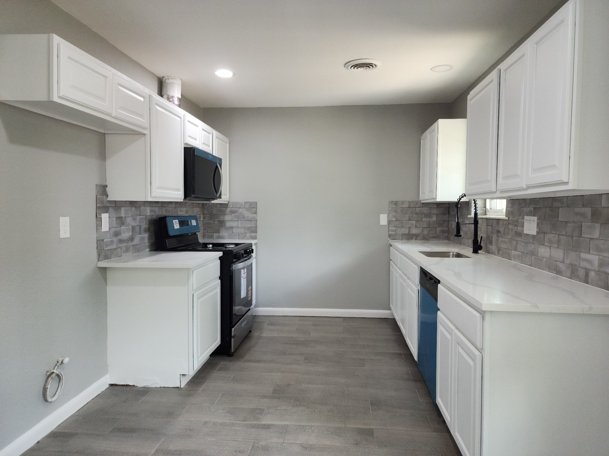 5914 Newquay Street Houston, TX 77085 - Photo 20 of 43 a kitchen with stainless steel appliances a sink a stove top oven a refrigerator and white cabinets