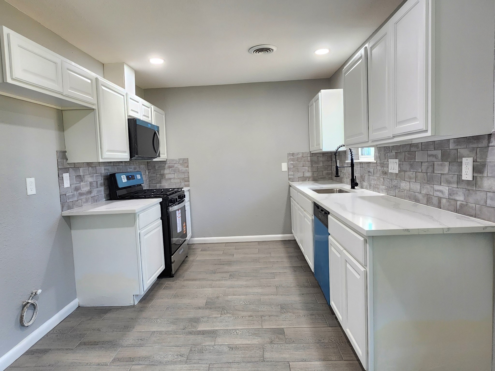 5914 Newquay Street Houston, TX 77085 - Photo 22 of 43 a kitchen with a sink stove top oven and cabinets