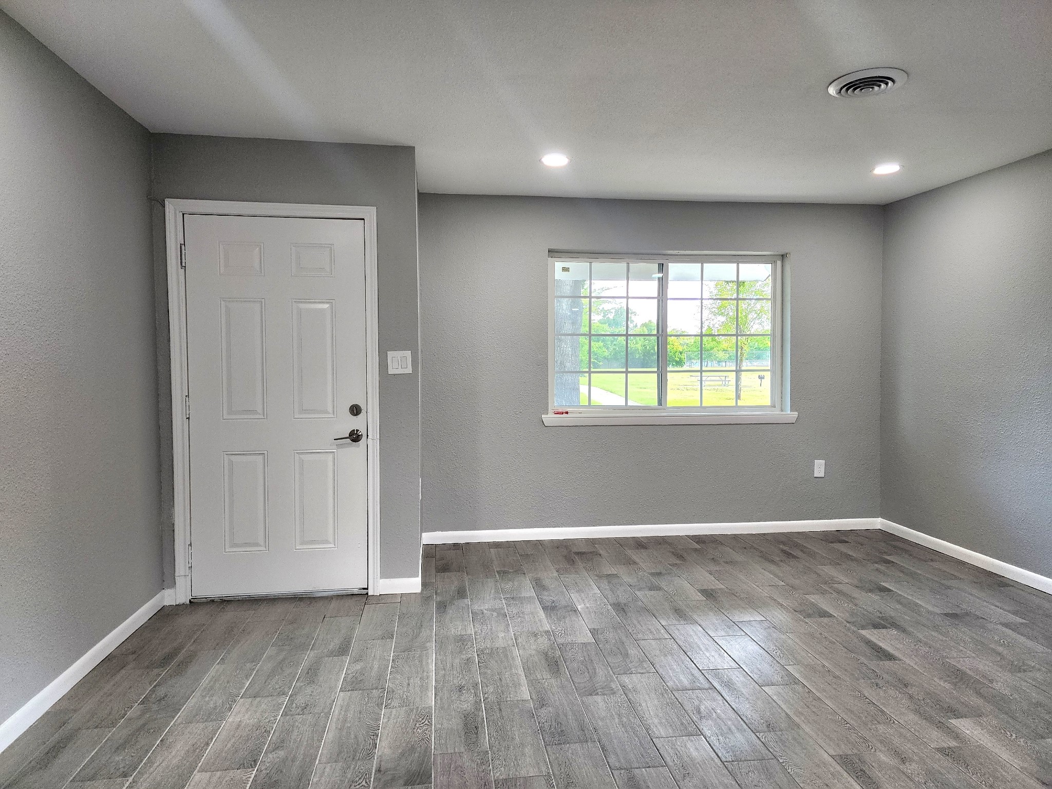5914 Newquay Street Houston, TX 77085 - Photo 6 of 43 a view of an empty room with wooden floor and a window