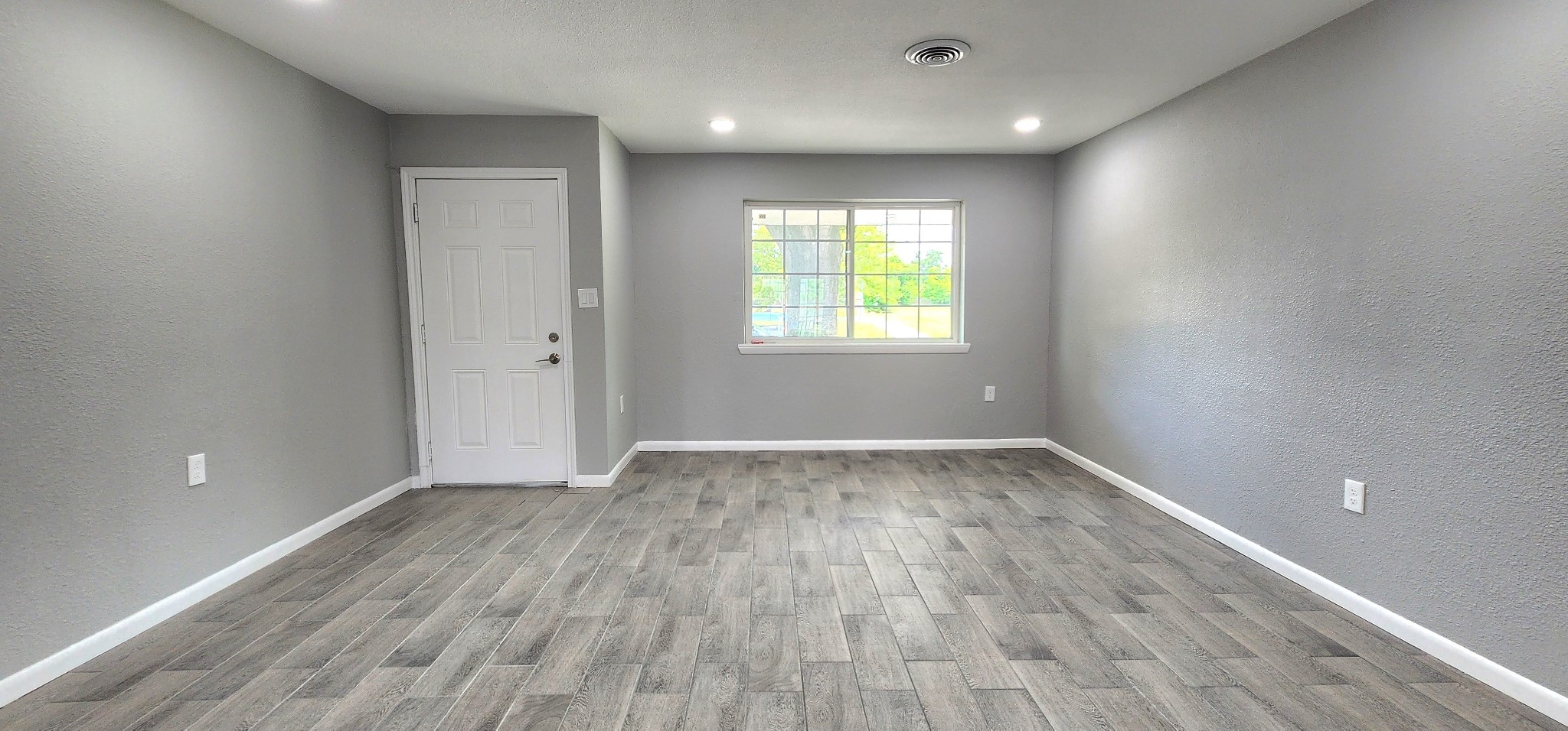5914 Newquay Street Houston, TX 77085 - Photo 7 of 43 an empty room with wooden floor and windows
