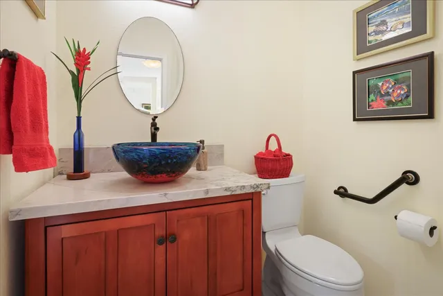 a bathroom with a toilet sink vanity and mirror