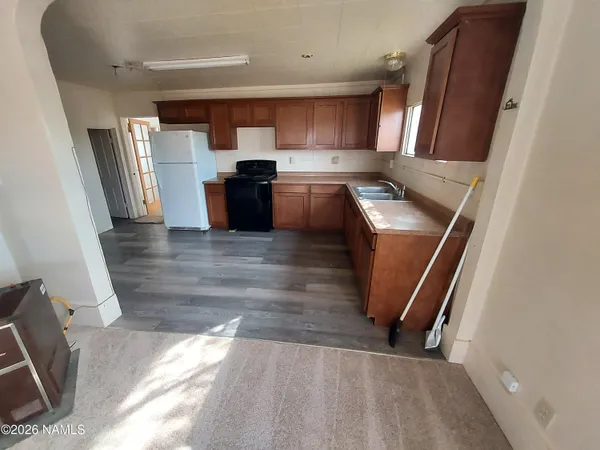 a view of kitchen with sink and refrigerator