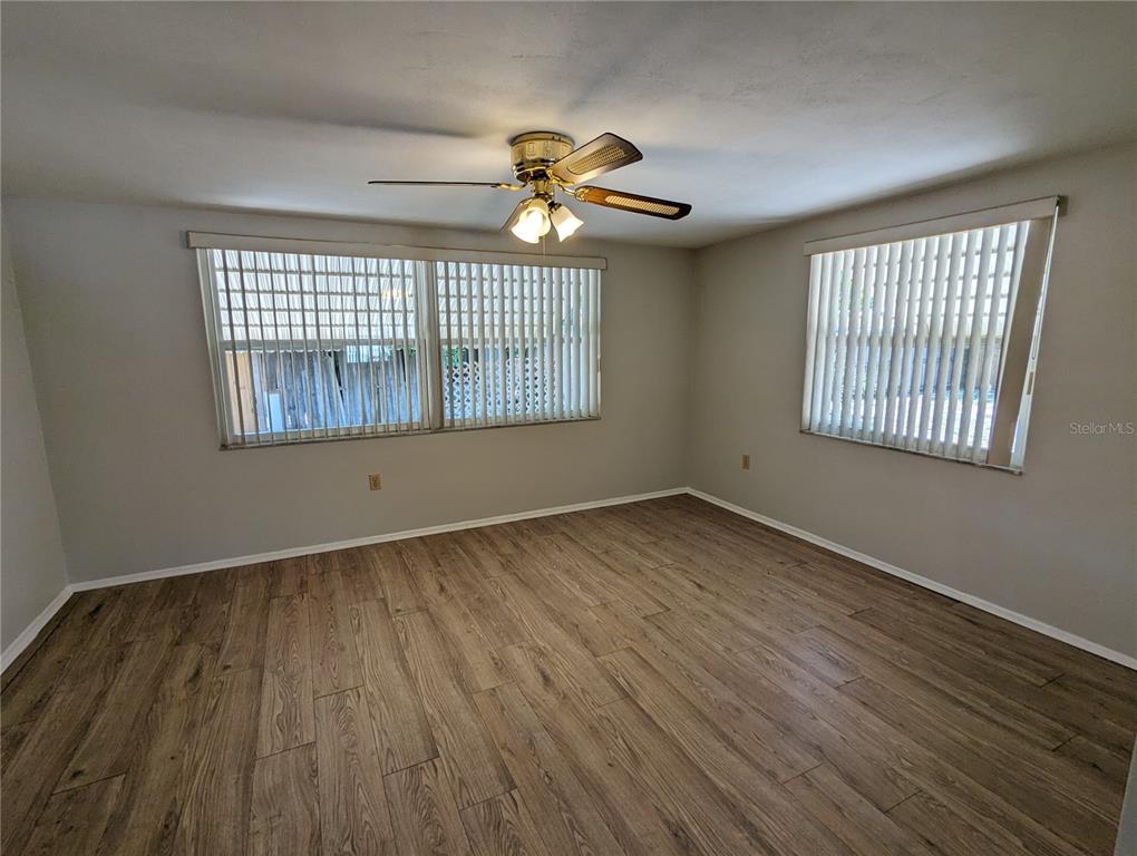 11230 Kapok Avenue Port Richey, FL 34668 - Photo 11 of 19 a view of an empty room with wooden floor and a window