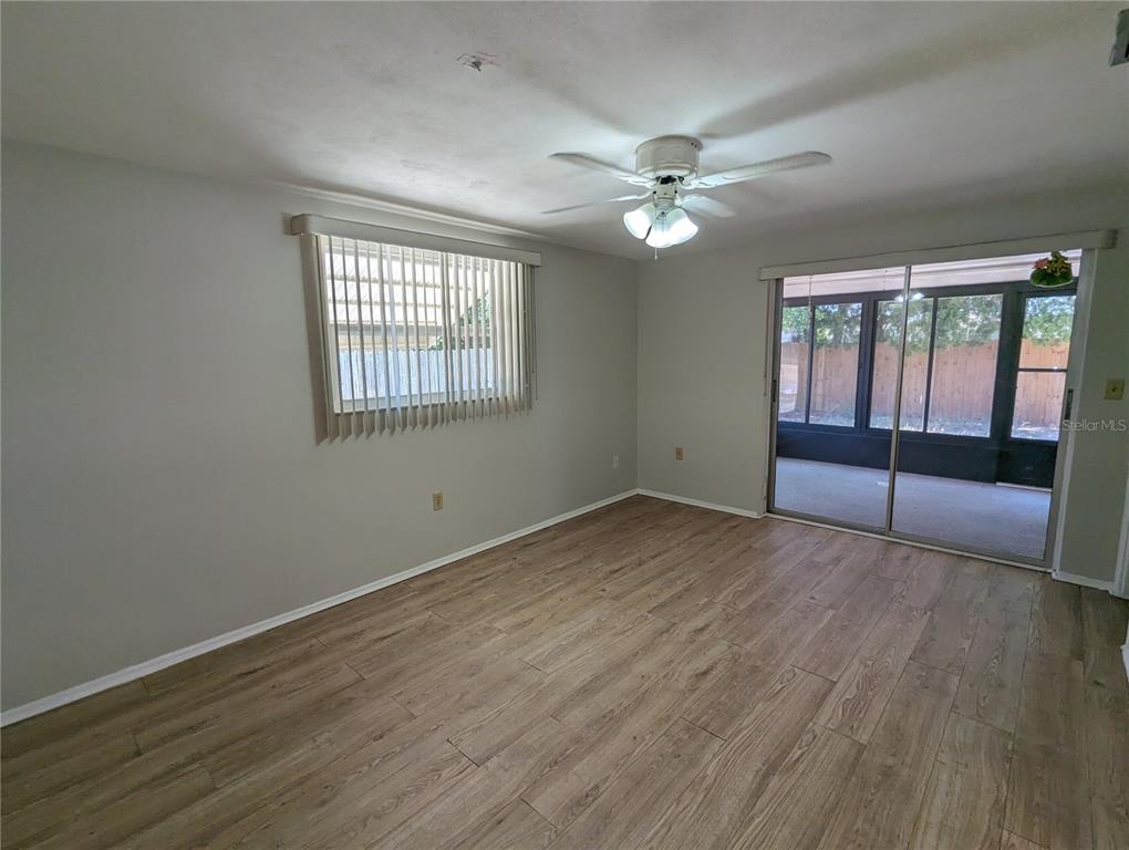 11230 Kapok Avenue Port Richey, FL 34668 - Photo 13 of 19 a view of an empty room with wooden floor and a window