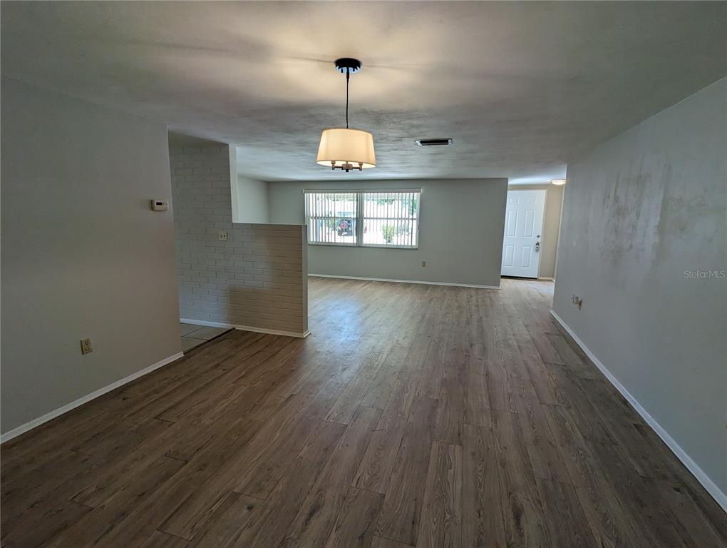 11230 Kapok Avenue Port Richey, FL 34668 - Photo 2 of 19 an empty room with wooden floor and windows