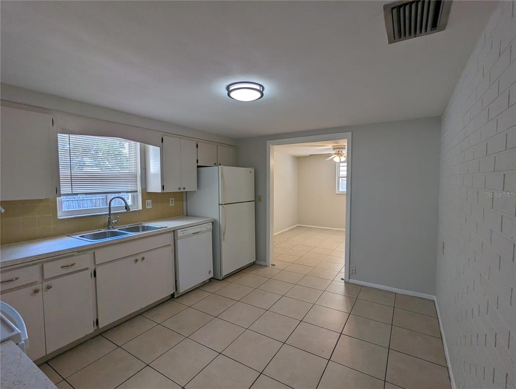 11230 Kapok Avenue Port Richey, FL 34668 - Photo 5 of 19 a kitchen with a refrigerator and microwave