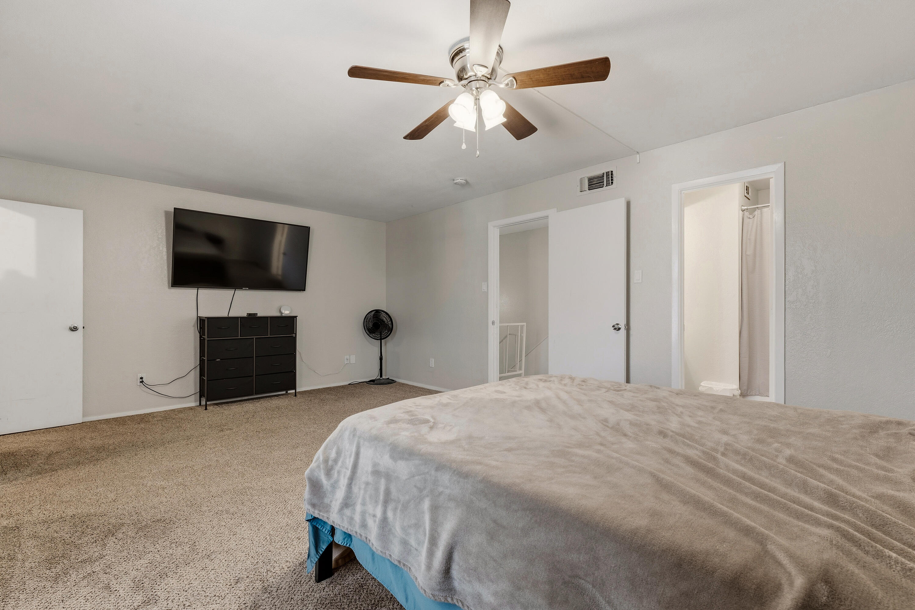 4725 48th Street Lubbock, TX 79414 - Photo 14 of 24 a bedroom with a bed and a flat tv screen on dresser