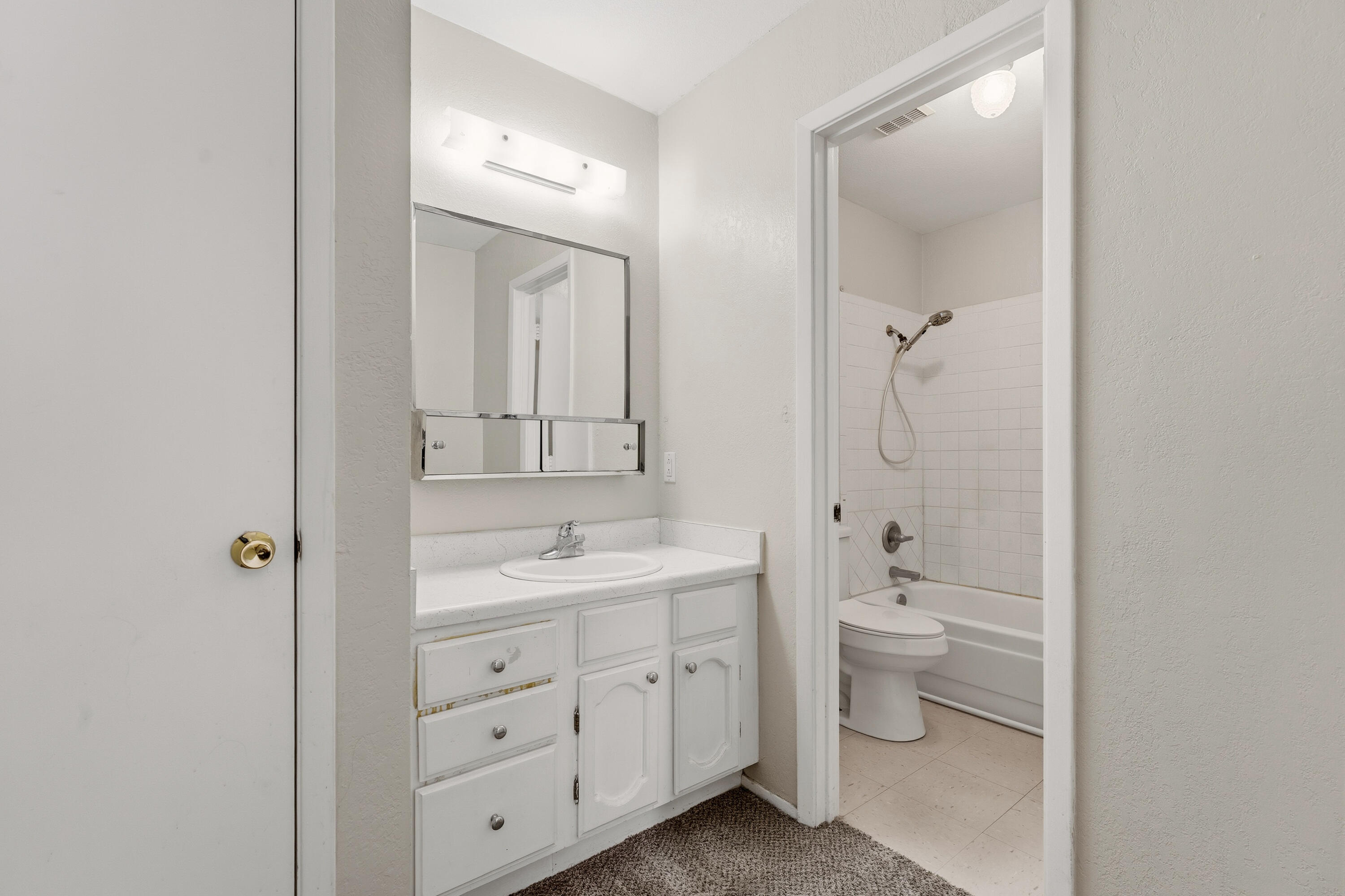 4725 48th Street Lubbock, TX 79414 - Photo 15 of 24 a spacious bathroom with a toilet a sink and mirror