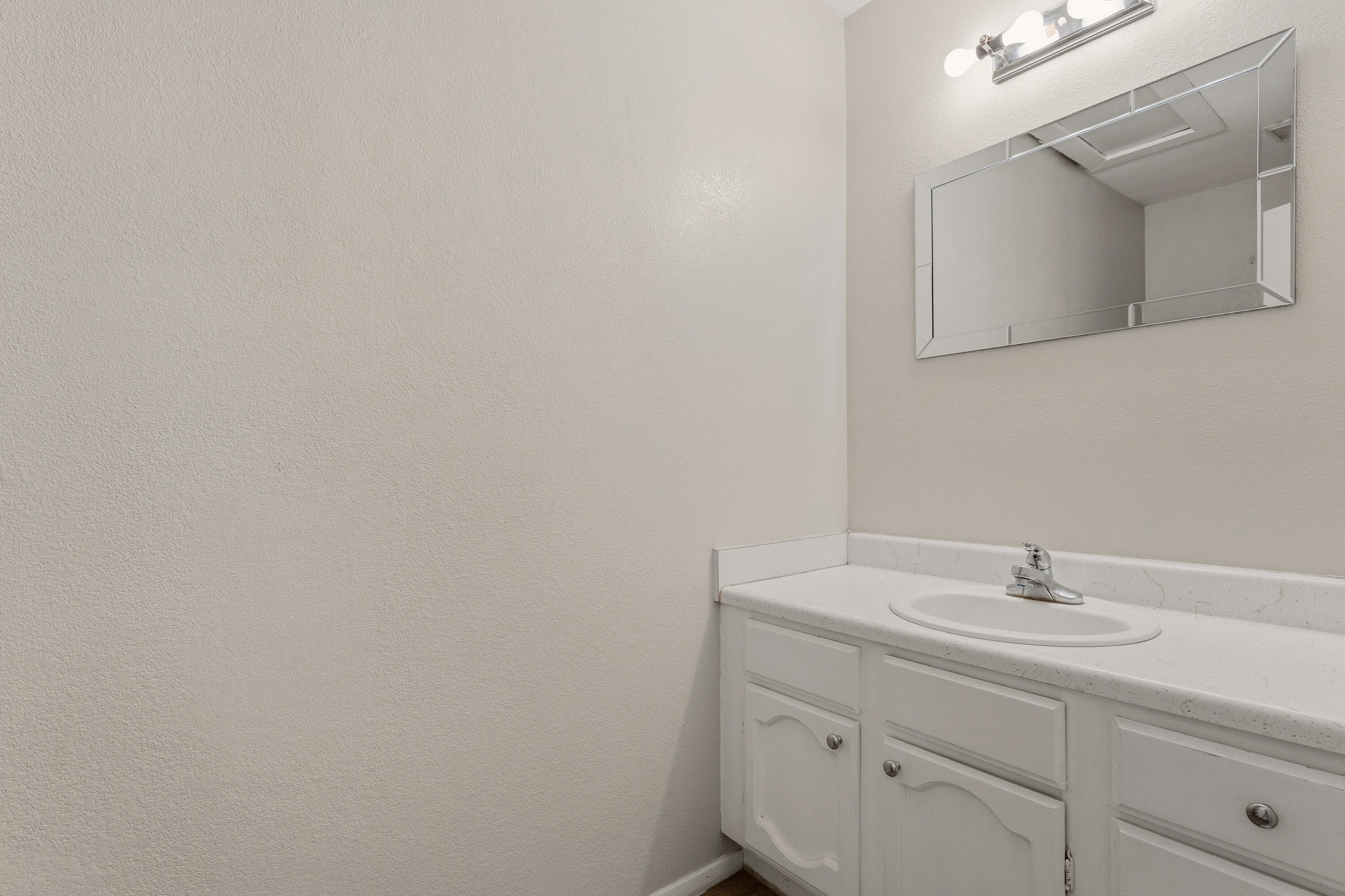 4725 48th Street Lubbock, TX 79414 - Photo 21 of 24 a bathroom with a sink and a mirror
