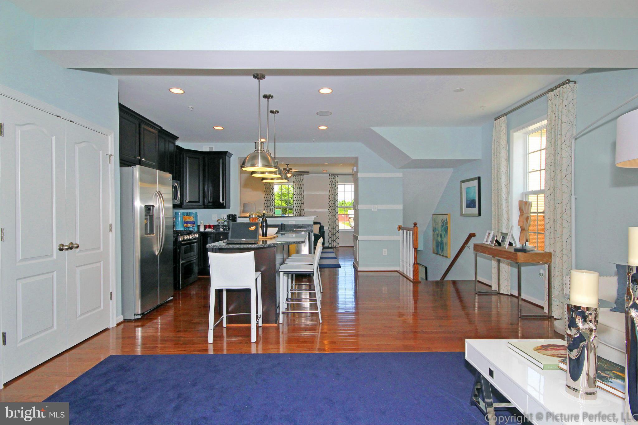 112 Mill Pond Road Frederick, MD 21701 - Photo 9 of 23 a living room with furniture a wooden floor and kitchen view
