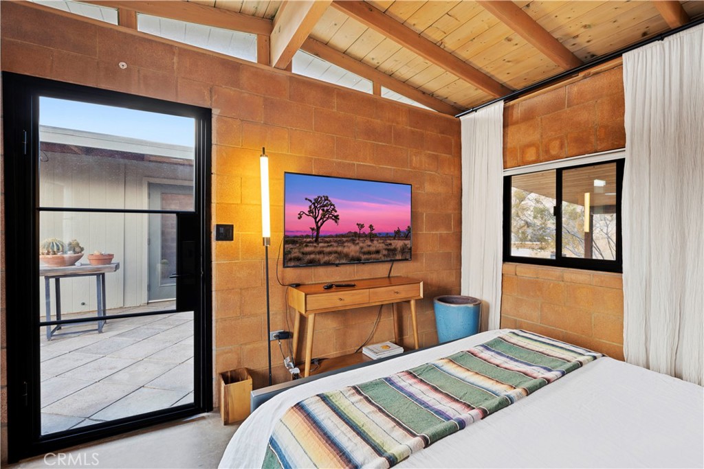 51222 Gamma Gulch Road Landers, CA 92285 - Photo 40 of 73 a bedroom with a bed and a flat screen tv