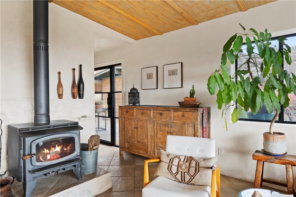 51222 Gamma Gulch Road Landers, CA 92285 - Photo 10 of 73 a living room with furniture a potted plant and a fireplace