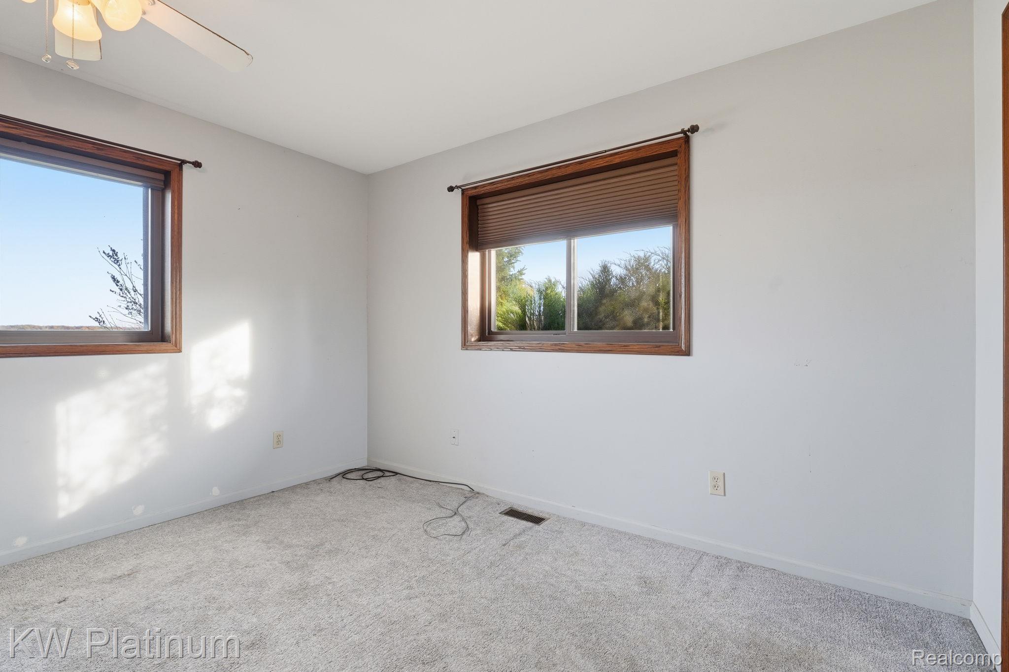 7383 Fisher Road Jeddo, MI 48032 - Photo 10 of 40 Carpeted empty room featuring baseboards and ceiling fan