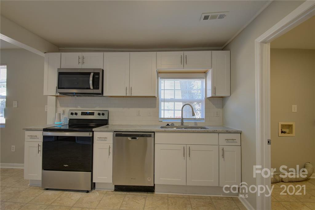 3917 Plainview Road Charlotte, NC 28208 - Photo 14 of 17 a kitchen with stainless steel appliances granite countertop a stove a sink and a microwave